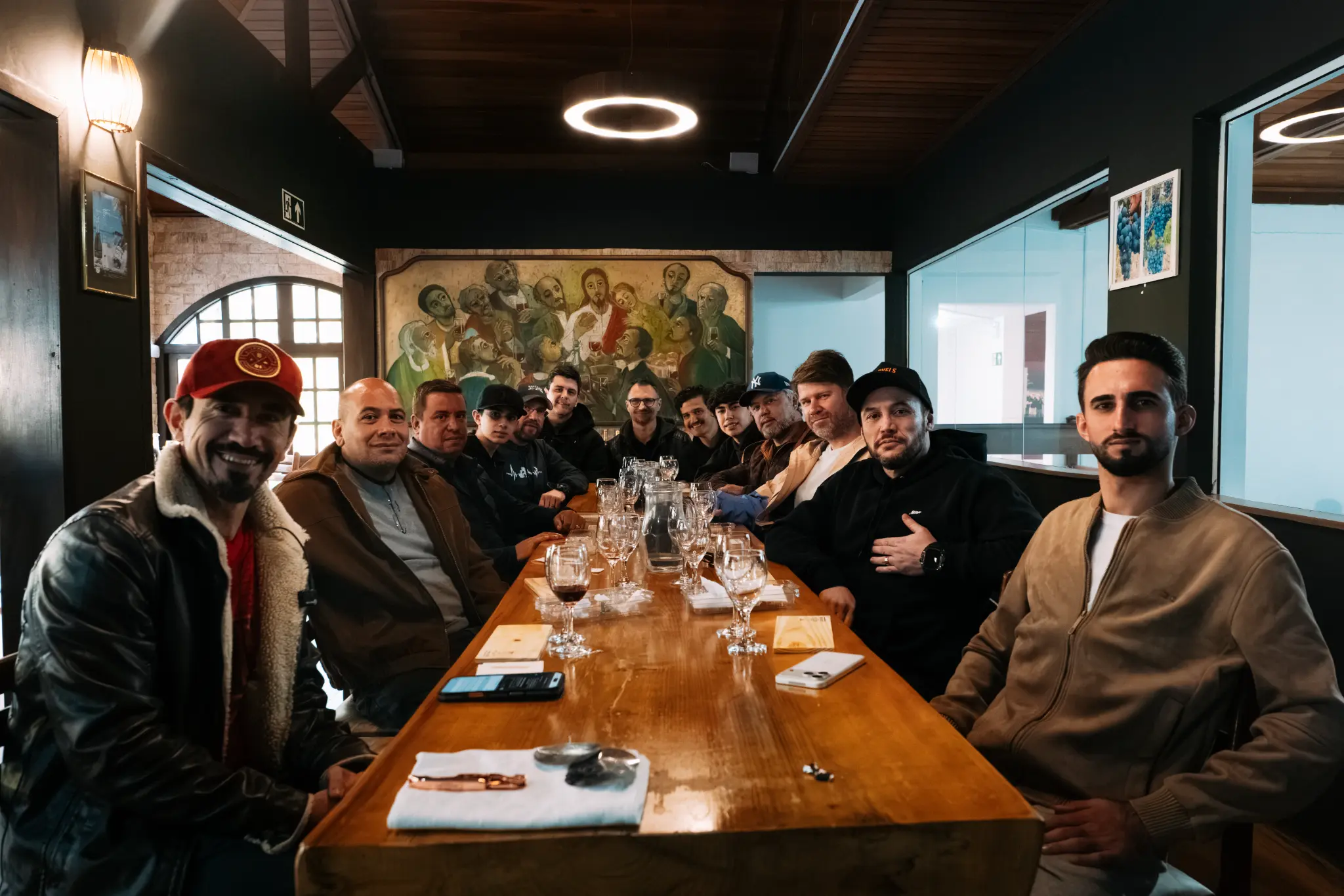 Grupo de homens reunido ao redor de uma mesa em convivência.